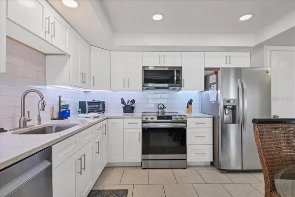 a kitchen with stainless steel appliances a stove microwave and refrigerator