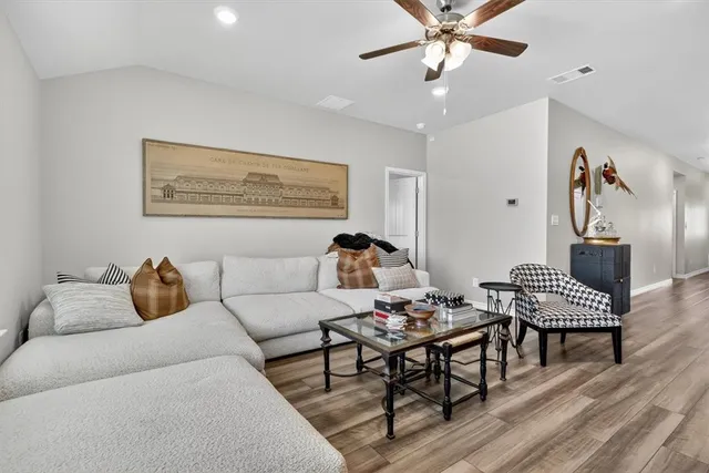 a living room with furniture and wooden floor