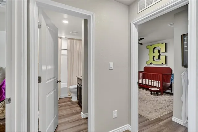 a view of a bedroom with a bed and wooden floor