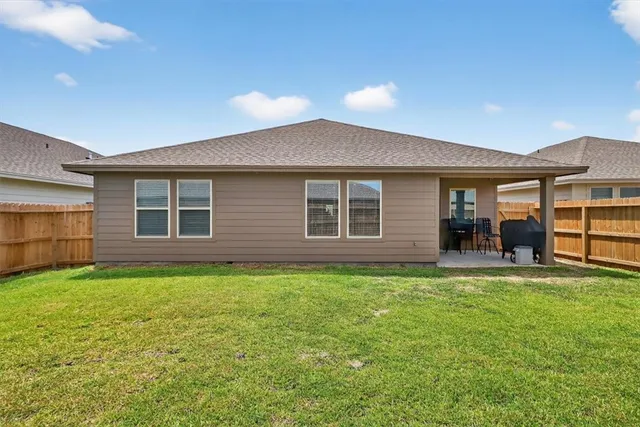 a view of a house with a yard and sitting area