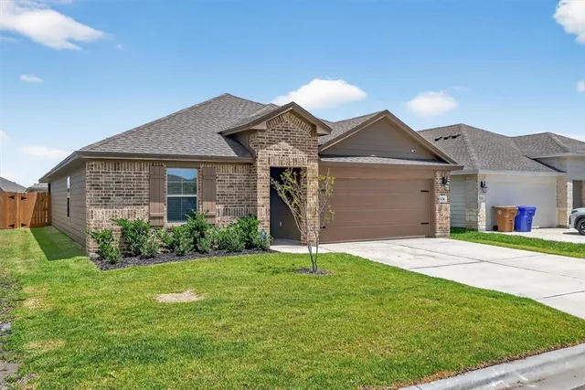 a front view of a house with a yard and garage