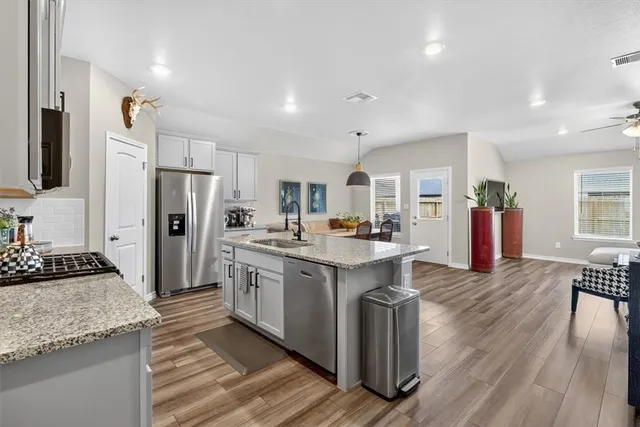 a kitchen with stainless steel appliances granite countertop a refrigerator stove microwave and sink