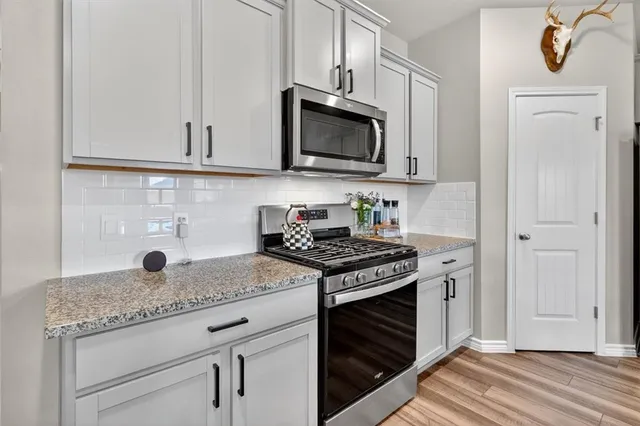 a kitchen with white cabinets and appliances