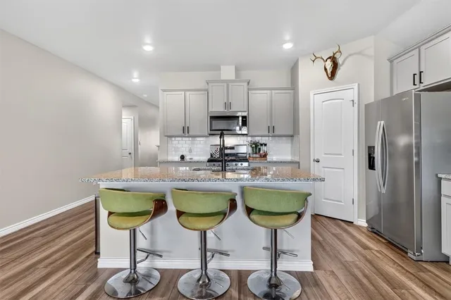 a kitchen with refrigerator and chairs