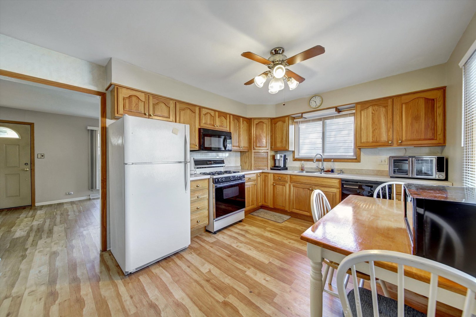 445 South Yale Avenue Addison, IL 60101 - Photo 6 of 20 a kitchen with stainless steel appliances a refrigerator a stove a sink dishwasher and a dining table with wooden floor