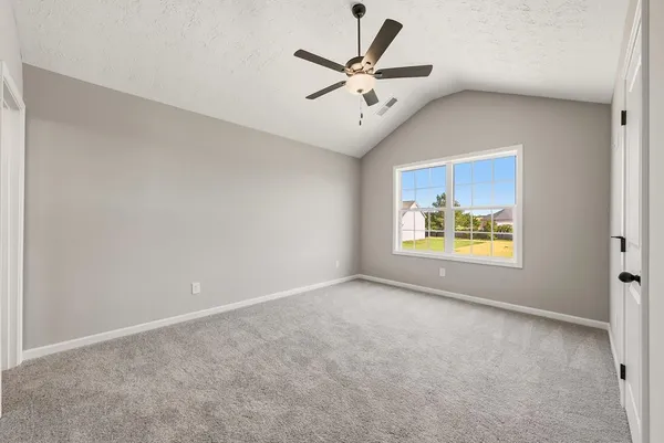 an empty room with a window and a ceiling fan