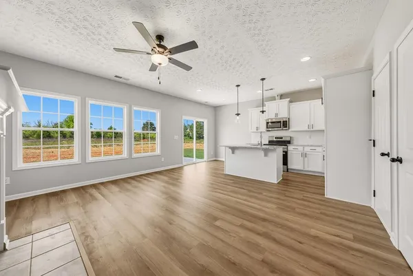 a large kitchen with stainless steel appliances kitchen island a large counter top and a wooden floors