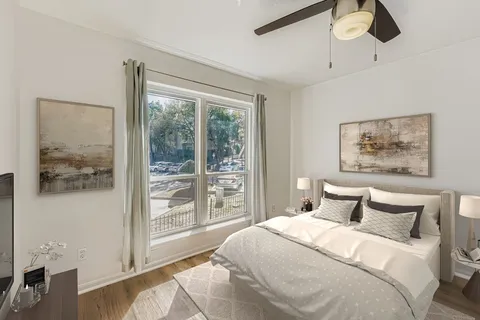 a bedroom with a bed and a painting on the wall