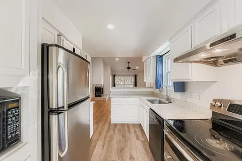 a kitchen with a refrigerator sink and cabinets
