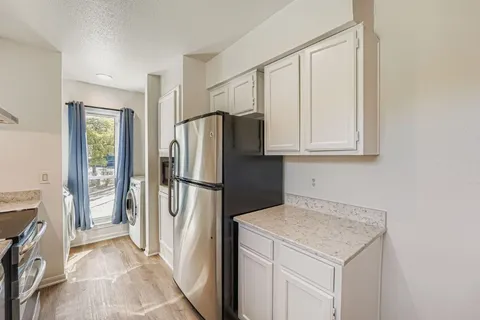 a kitchen with stainless steel appliances a refrigerator and a stove top oven