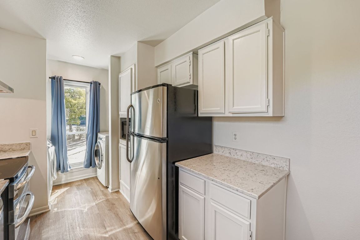 2450 Wickersham Lane, Unit 604 Austin, TX 78741 - Photo 9 of 22 a kitchen with a refrigerator sink and cabinets