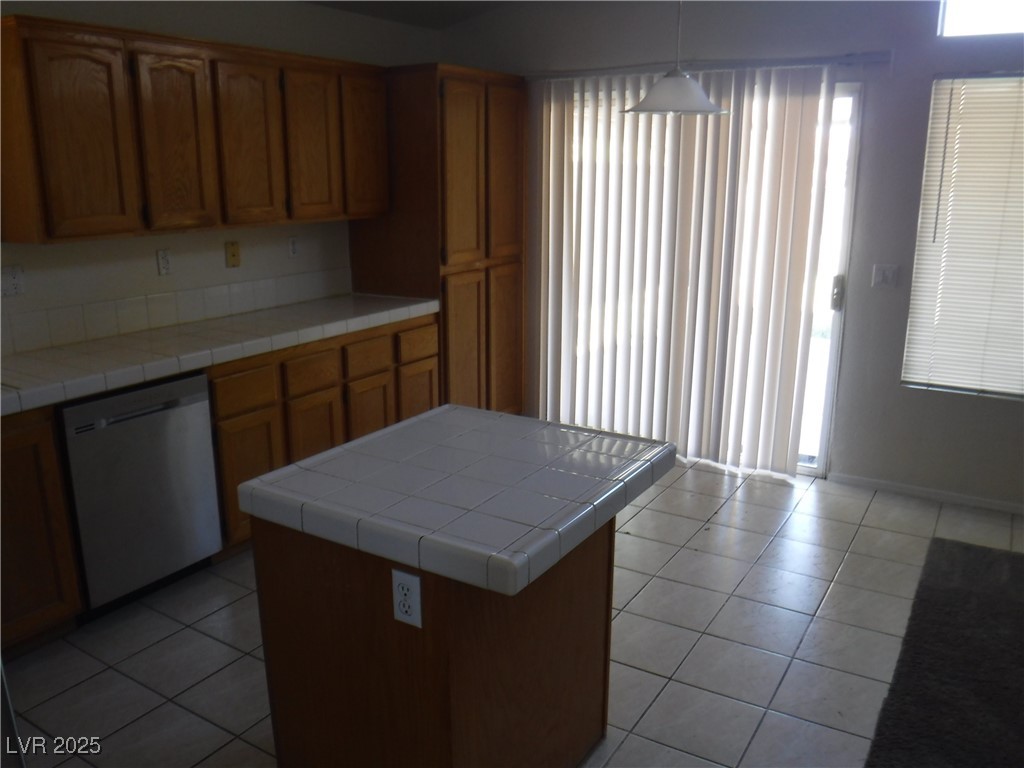 2422 Tottingham Road Henderson, NV 89074 - Photo 8 of 25 Kitchen featuring tile counters, dishwasher, light tile patterned floors, and brown cabinetry