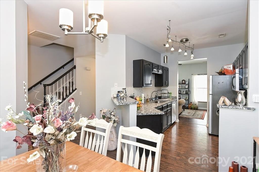 1262 Branson Road Northwest Concord, NC 28027 - Photo 13 of 34 a view of a dining room with furniture a rug and wooden floor