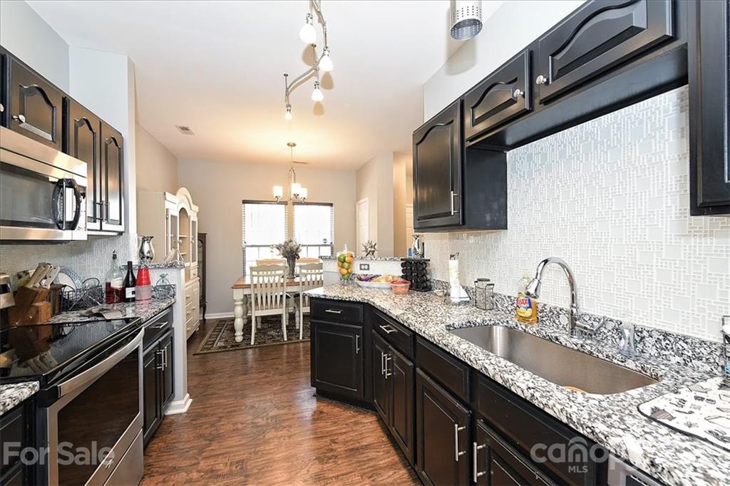 1262 Branson Road Northwest Concord, NC 28027 - Photo 14 of 34 a kitchen with granite countertop a sink stove and cabinets