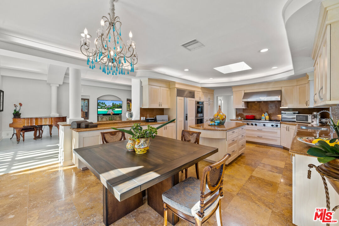 23318 Park Colombo Calabasas, CA 91302 - Photo 13 of 36 a dining room with wooden floor a chandelier a wooden table and chairs