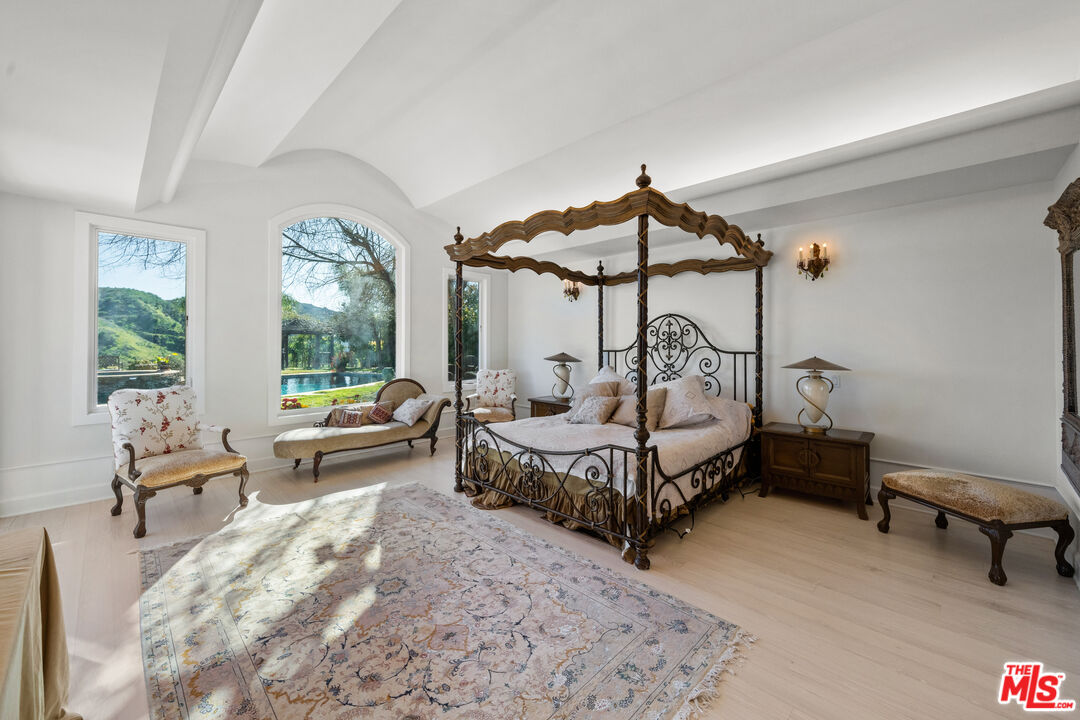 23318 Park Colombo Calabasas, CA 91302 - Photo 15 of 36 a bedroom with a bed a chandelier and a window