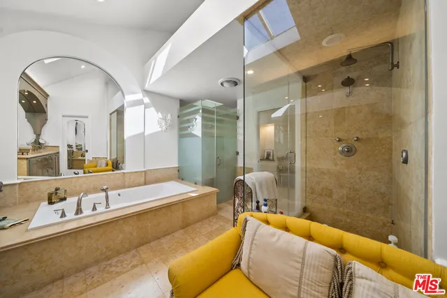 a spacious bathroom with a tub sink and mirror
