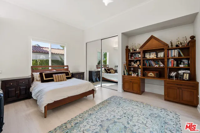 a bedroom with a bed a dresser and book shelf