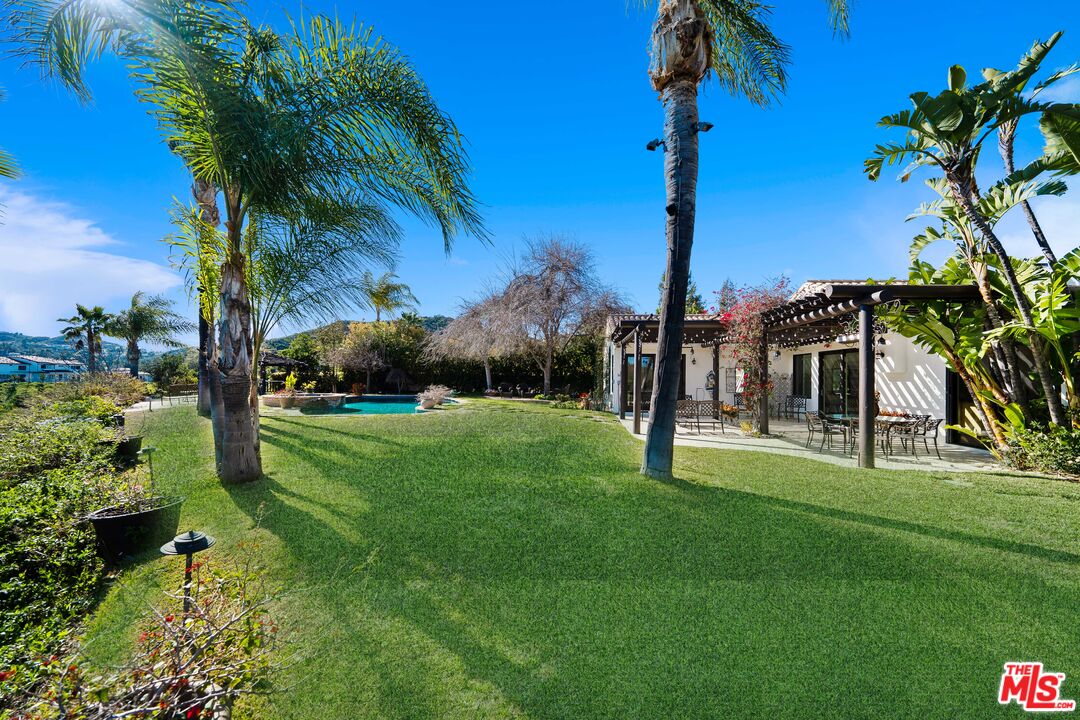 23318 Park Colombo Calabasas, CA 91302 - Photo 29 of 36 a view of a house with a big yard and palm trees