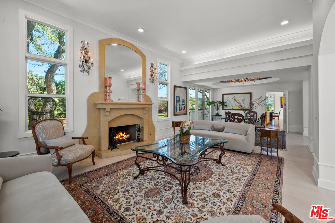 23318 Park Colombo Calabasas, CA 91302 - Photo 6 of 36 a living room with furniture a rug a fireplace and a large window