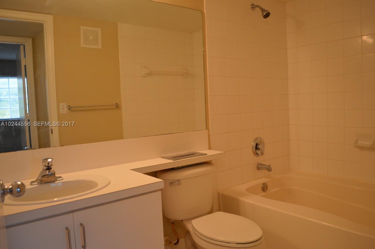 2011 Renaissance Boulevard, Unit 201 Miramar, FL 33025 - Photo 17 of 22 a bathroom with a sink a toilet and shower