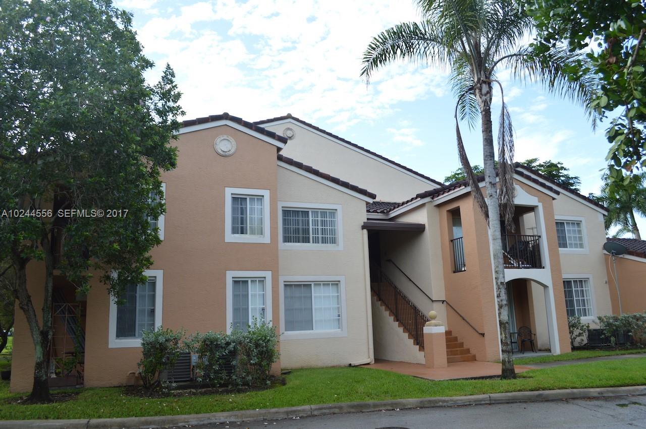 2011 Renaissance Boulevard, Unit 201 Miramar, FL 33025 - Photo 2 of 22 a front view of a house with a yard and garage