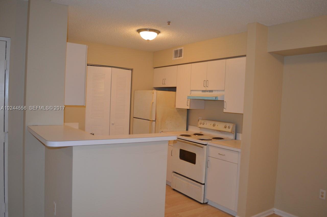 2011 Renaissance Boulevard, Unit 201 Miramar, FL 33025 - Photo 5 of 22 a kitchen with cabinets and white stainless steel appliances