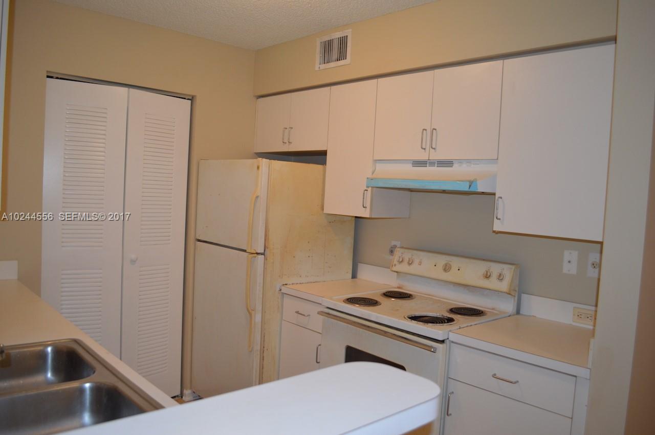 2011 Renaissance Boulevard, Unit 201 Miramar, FL 33025 - Photo 7 of 22 a kitchen with a sink a stove and refrigerator