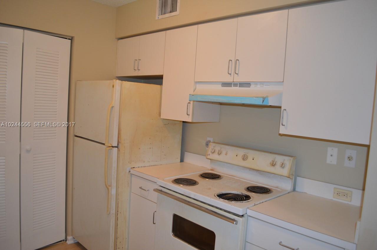 2011 Renaissance Boulevard, Unit 201 Miramar, FL 33025 - Photo 8 of 22 a kitchen with a refrigerator and white cabinets