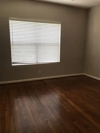 a view of a room with wooden floor and a window