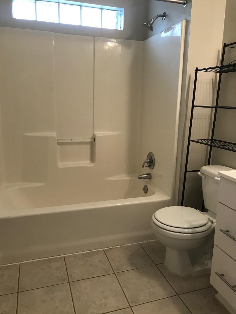 315 Branard Street, Unit 4 Houston, TX 77006 - Photo 13 of 20 a white toilet sitting next to a bath tub and a shower