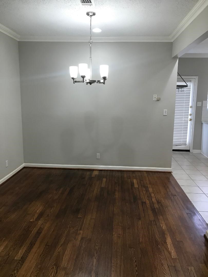 315 Branard Street, Unit 4 Houston, TX 77006 - Photo 8 of 20 an empty room with wooden floor chandelier and glass door