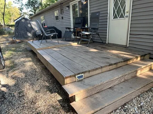 a view of a backyard with chairs and wooden fence