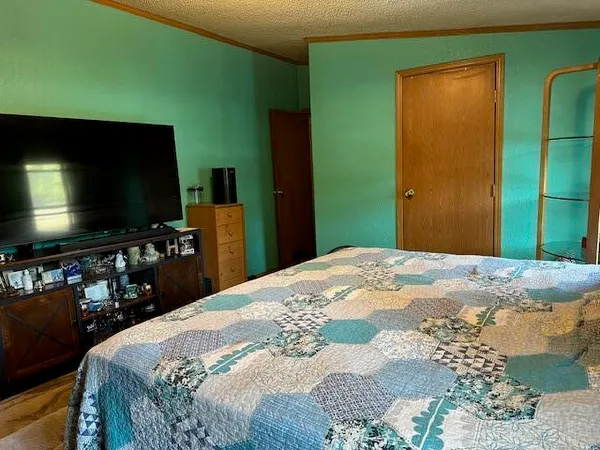 a bedroom with a bed and a flat screen tv