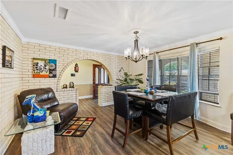 a view of a dining room with furniture a chandelier and wooden floor