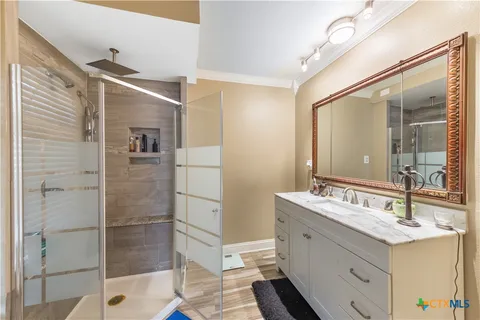 a bathroom with a double vanity sink mirror and shower