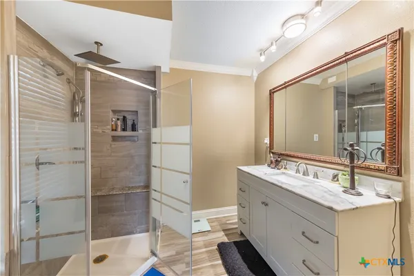 a bathroom with a double vanity sink mirror and shower