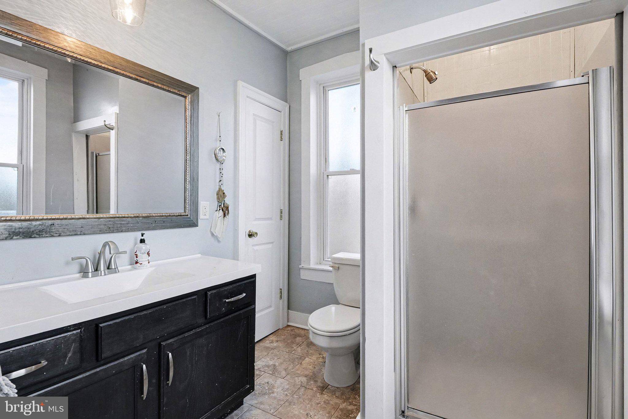 153 East Main Street Biglerville, PA 17307 - Photo 23 of 39 a bathroom with a double vanity sink toilet mirror and shower