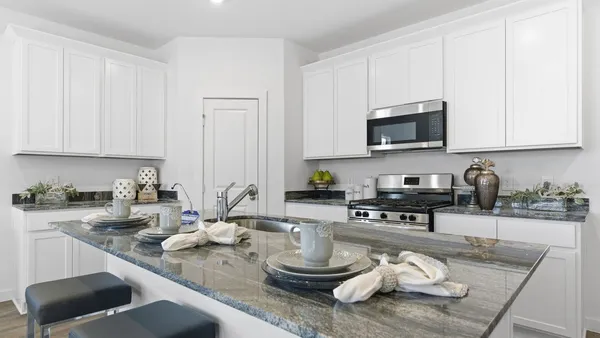 a kitchen with stainless steel appliances granite countertop a sink stove and microwave