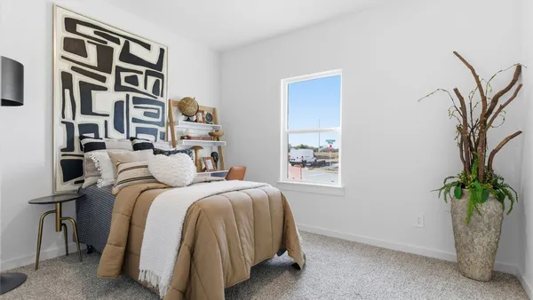 a bedroom with a bed and a potted plant