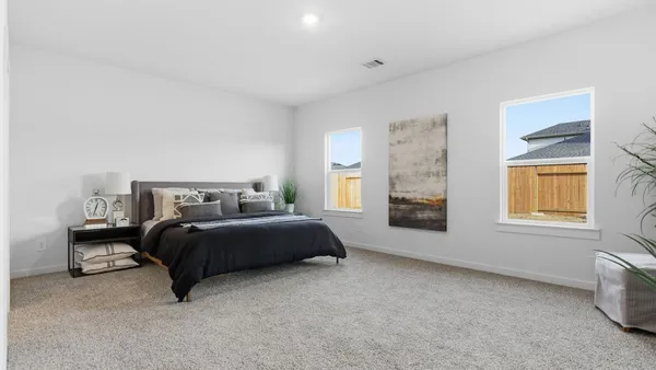 a spacious bedroom with a bed and window