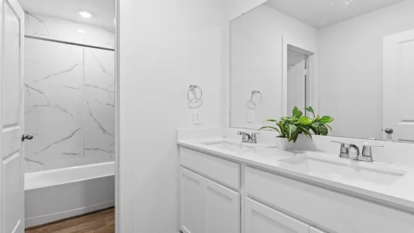 a bathroom with a granite countertop sink and a bathtub