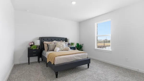 a large bed sitting in a bedroom next to a window