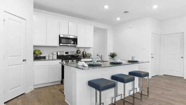 a kitchen with a sink cabinets and wooden floor