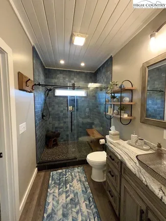 a bathroom with a granite countertop sink toilet and shower