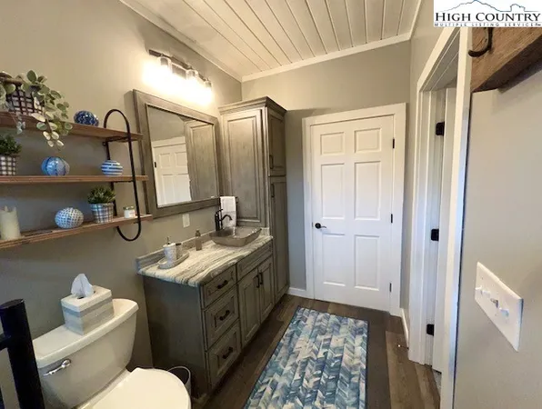 a bathroom with a granite countertop sink mirror vanity and toilet