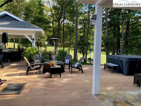 a view of a patio with a table and chairs and couches under an umbrella