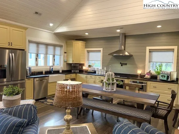 a kitchen with a stove a refrigerator and couches