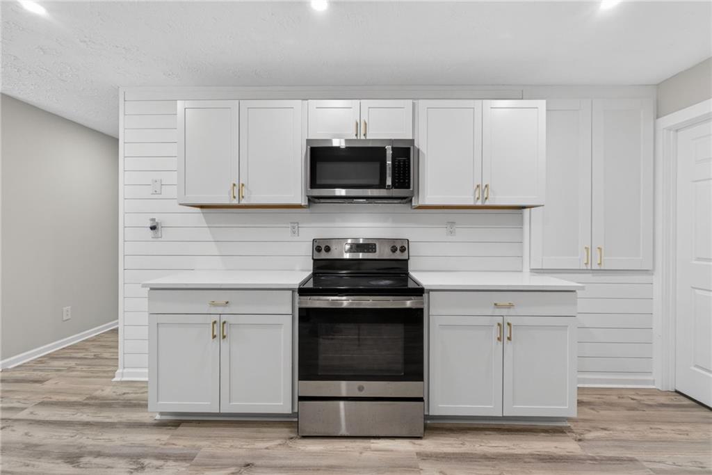7630 Rico Road Palmetto, GA 30268 - Photo 16 of 53 a kitchen with white cabinets and stainless steel appliances
