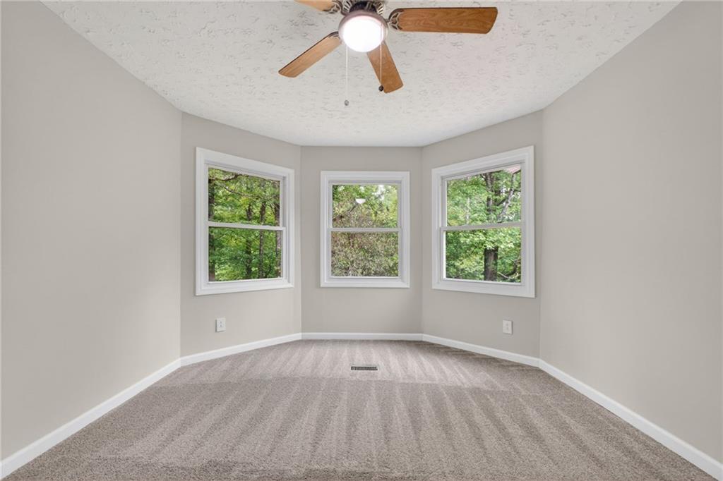 7630 Rico Road Palmetto, GA 30268 - Photo 29 of 53 an empty room with windows and chandelier fan